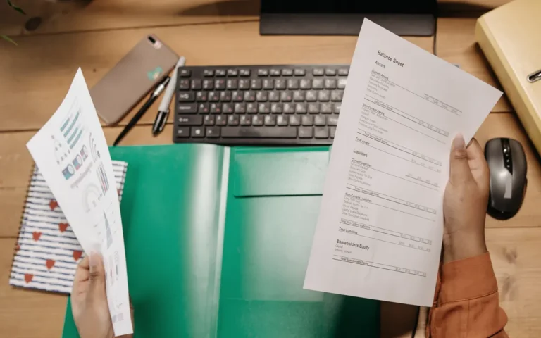 Mãos revisando um extrato financeiro sobre a mesa de trabalho