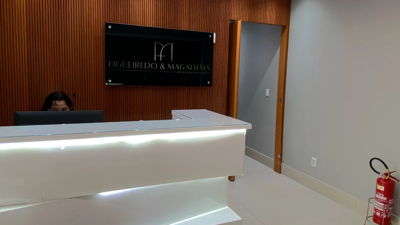 Recepção do escritório Figueiredo & Magalhães Advogados em Goiânia, com o painel da logo