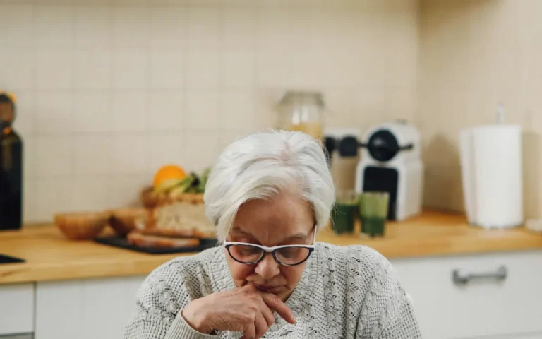 Senhora idosa pensativa na cozinha de casa